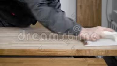 木匠正在加工木板，用磨砂纸研磨，在表面摩擦，用手特写